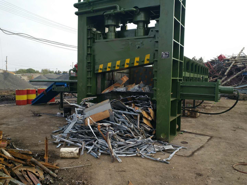 What is the primary purpose of a heavy-duty scrap metal shearing baler